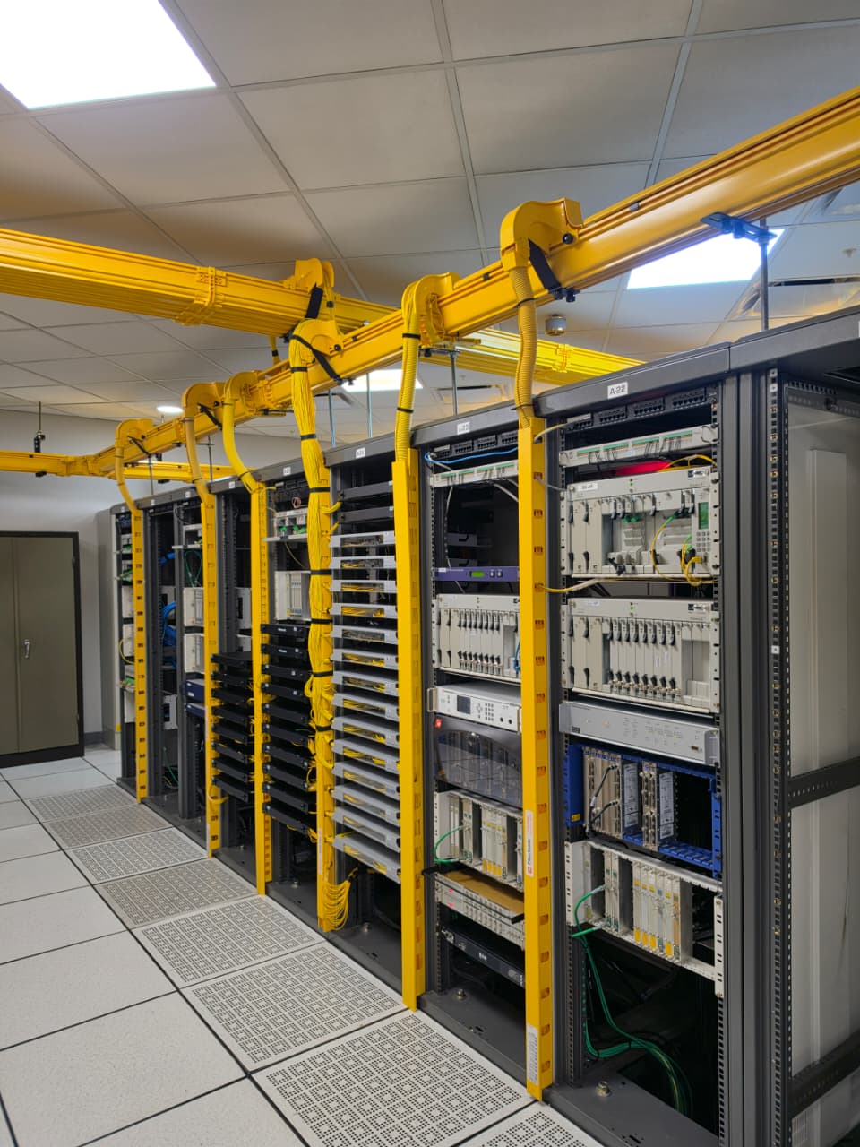 Sala de racks con bandejas de fibra óptica y canalización guiada de FIBERSEGN